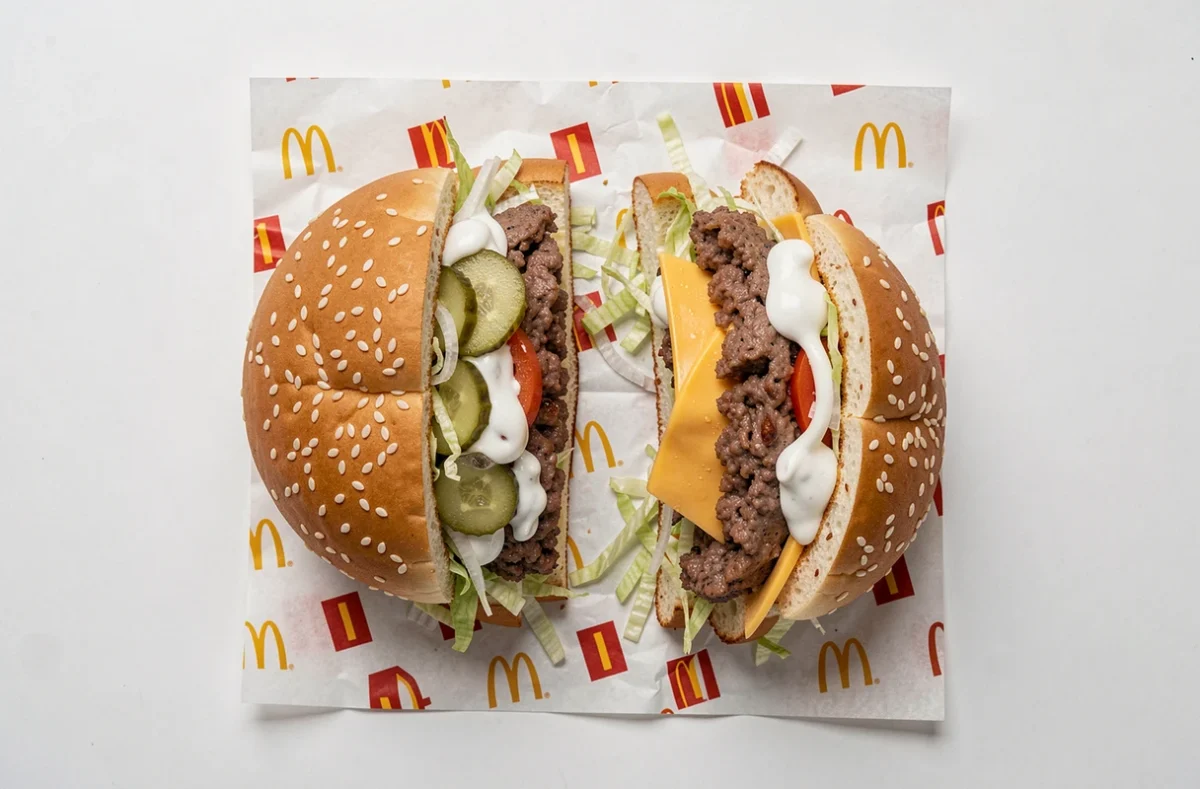 Big Mac décomposé en ses ingrédients sur un emballage McDonald's, vue de dessus en style éditorial food photography
